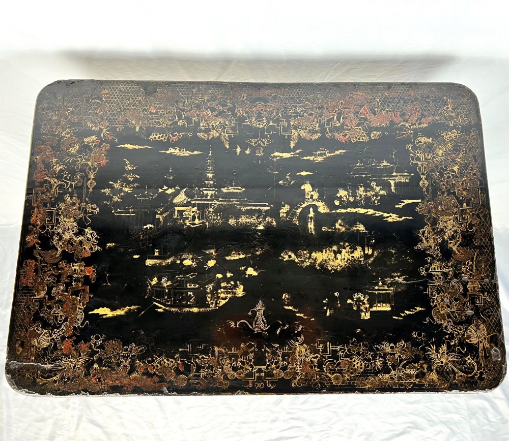 A Regency era black lacquered work table featuring detailed gold chinoiserie motifs, turned legs, a stretcher base, and carved paw feet. View II