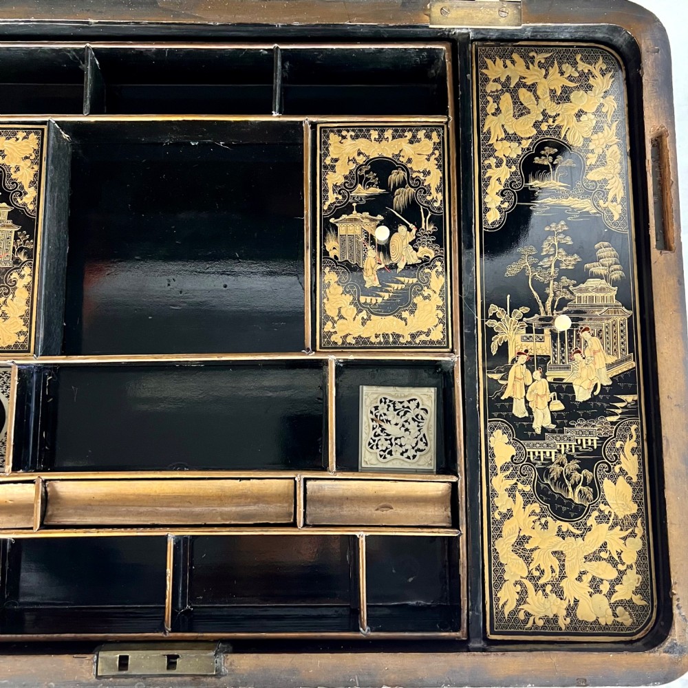 A Regency era black lacquered work table featuring detailed gold chinoiserie motifs, turned legs, a stretcher base, and carved paw feet. View V