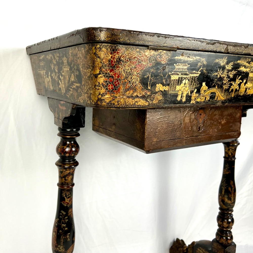 A Regency era black lacquered work table featuring detailed gold chinoiserie motifs, turned legs, a stretcher base, and carved paw feet. View IX