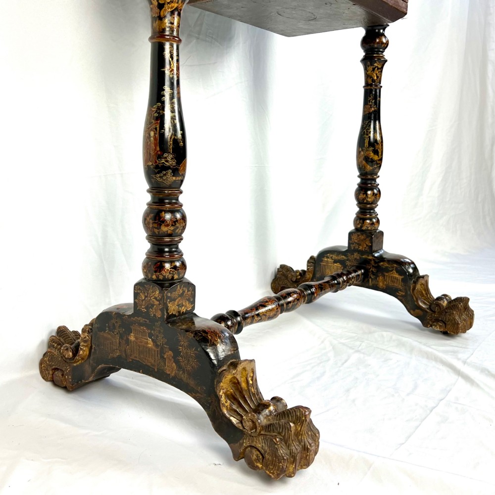 A Regency era black lacquered work table featuring detailed gold chinoiserie motifs, turned legs, a stretcher base, and carved paw feet. View XI