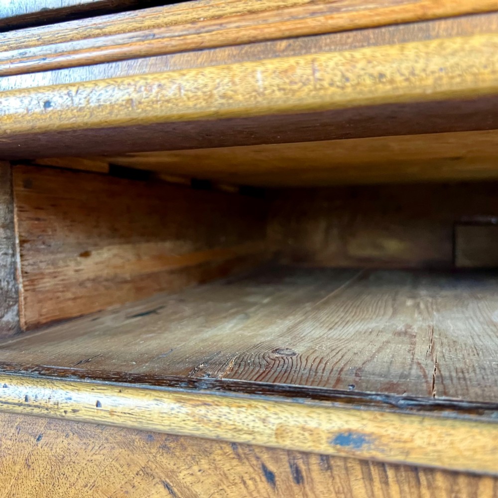 An early 18th-century Queen Anne walnut chest on stand featuring crossbanded drawers, brass teardrop handles, and cabriole legs. View XII