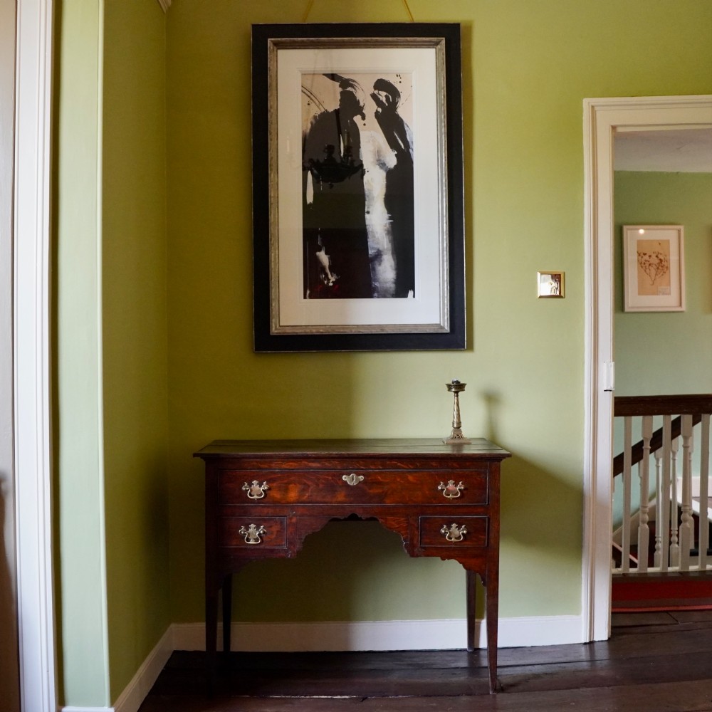 An 18th-century Georgian dark oak lowboy side table featuring three drawers with brass handles, a shaped apron, and slender square legs. View II