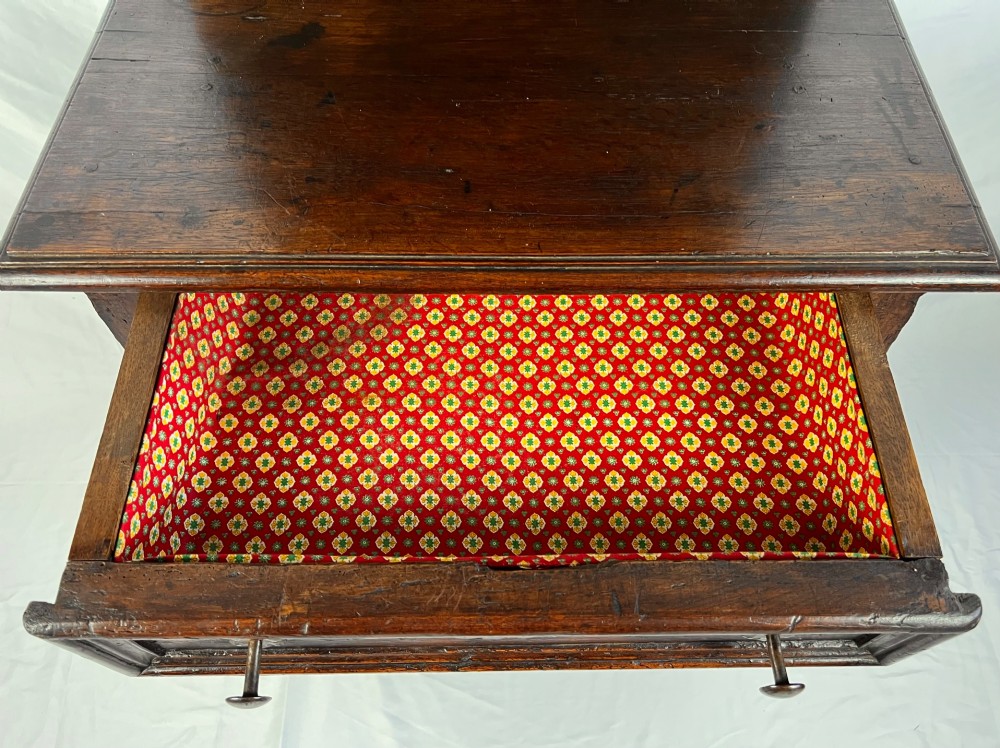 An 18th-century dark chestnut wood lavabo cabinet featuring a carved backboard mounted with a pewter cistern above a matching pewter basin. View III