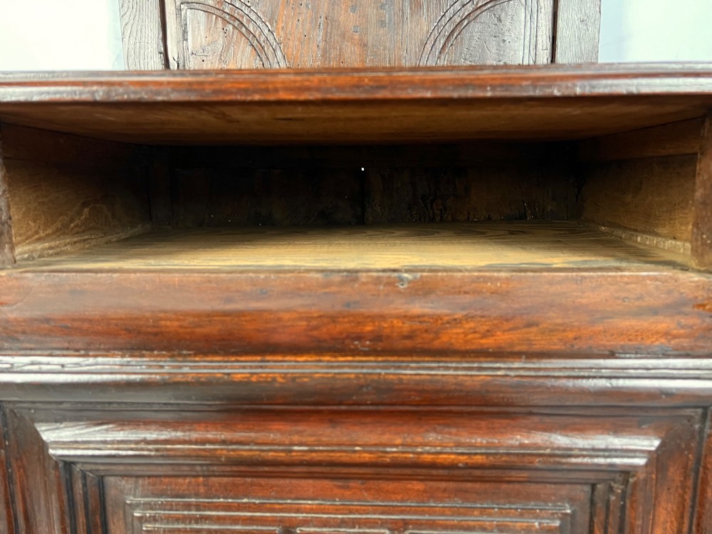 An 18th-century dark chestnut wood lavabo cabinet featuring a carved backboard mounted with a pewter cistern above a matching pewter basin. View IV