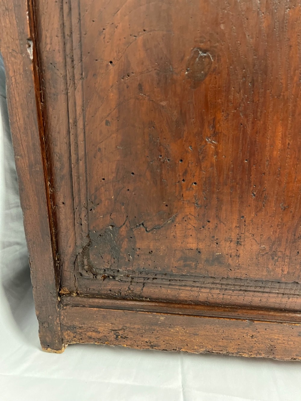 An 18th-century dark chestnut wood lavabo cabinet featuring a carved backboard mounted with a pewter cistern above a matching pewter basin. View XI
