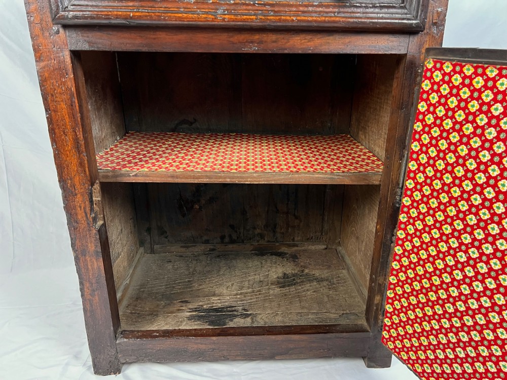 An 18th-century dark chestnut wood lavabo cabinet featuring a carved backboard mounted with a pewter cistern above a matching pewter basin. View XII