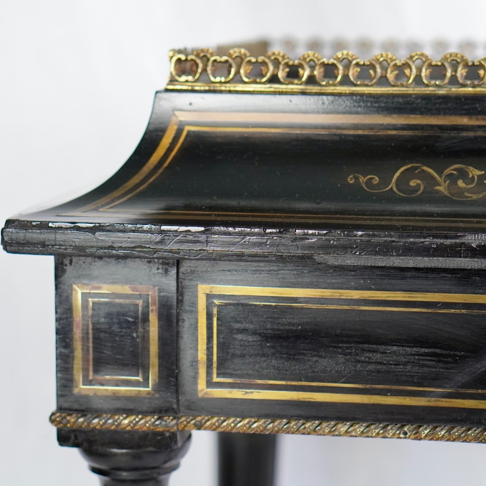A French Napoleon III ebonised jardiniere stand featuring gilt highlights, inset painted porcelain plaques, a pierced brass gallery top, turned legs, and an arched lower stretcher. View III