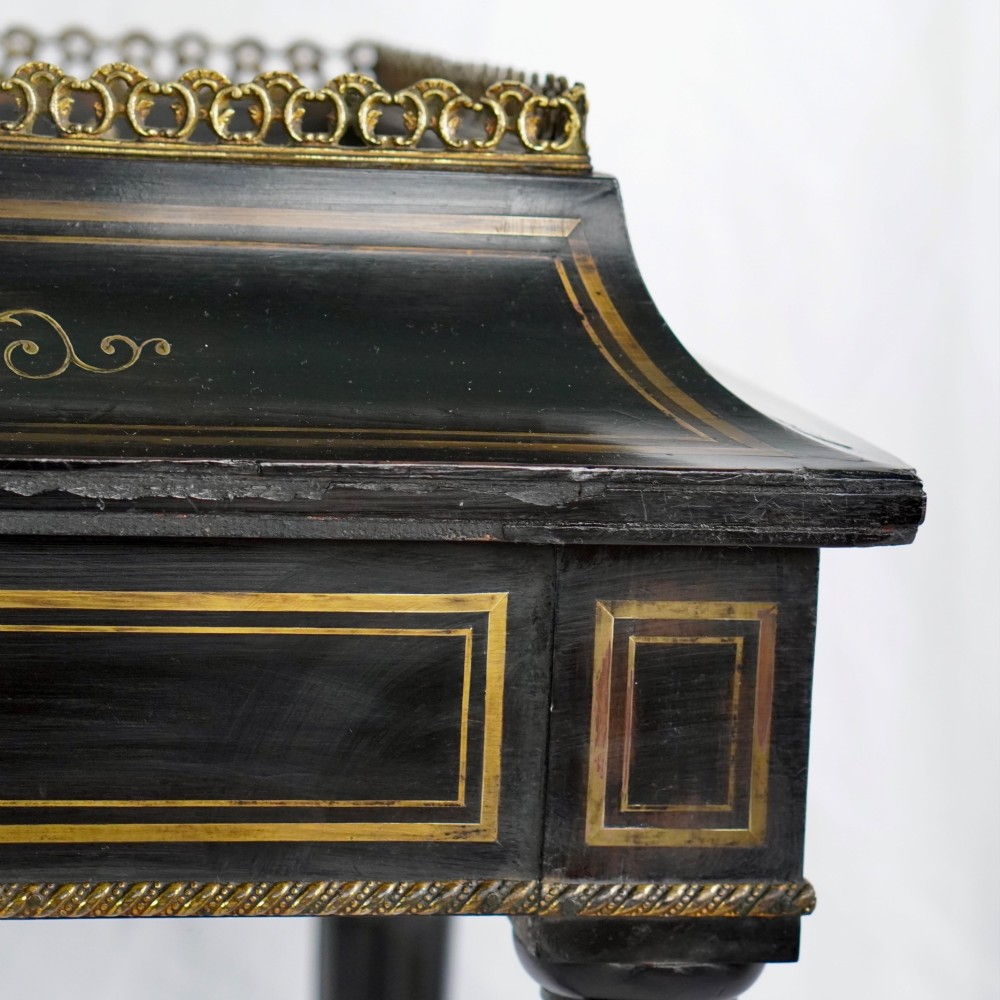 A French Napoleon III ebonised jardiniere stand featuring gilt highlights, inset painted porcelain plaques, a pierced brass gallery top, turned legs, and an arched lower stretcher. View IV