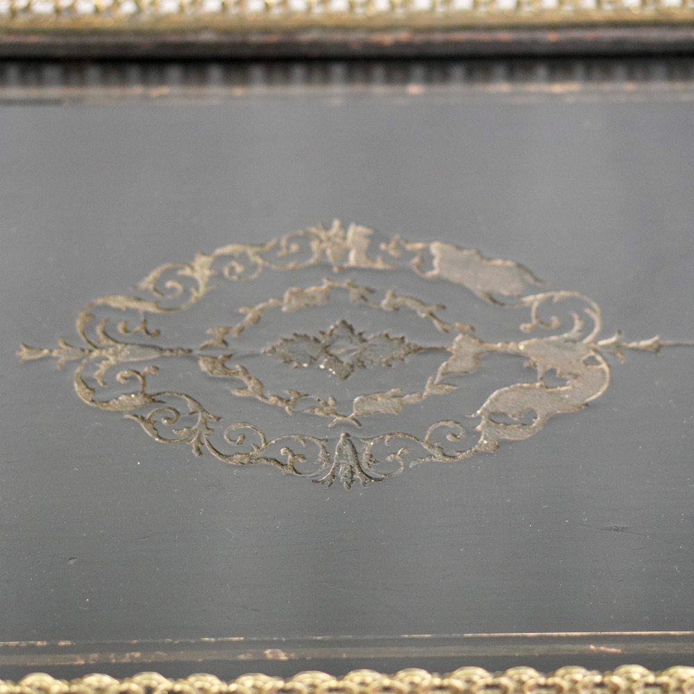 A French Napoleon III ebonised jardiniere stand featuring gilt highlights, inset painted porcelain plaques, a pierced brass gallery top, turned legs, and an arched lower stretcher. View VII