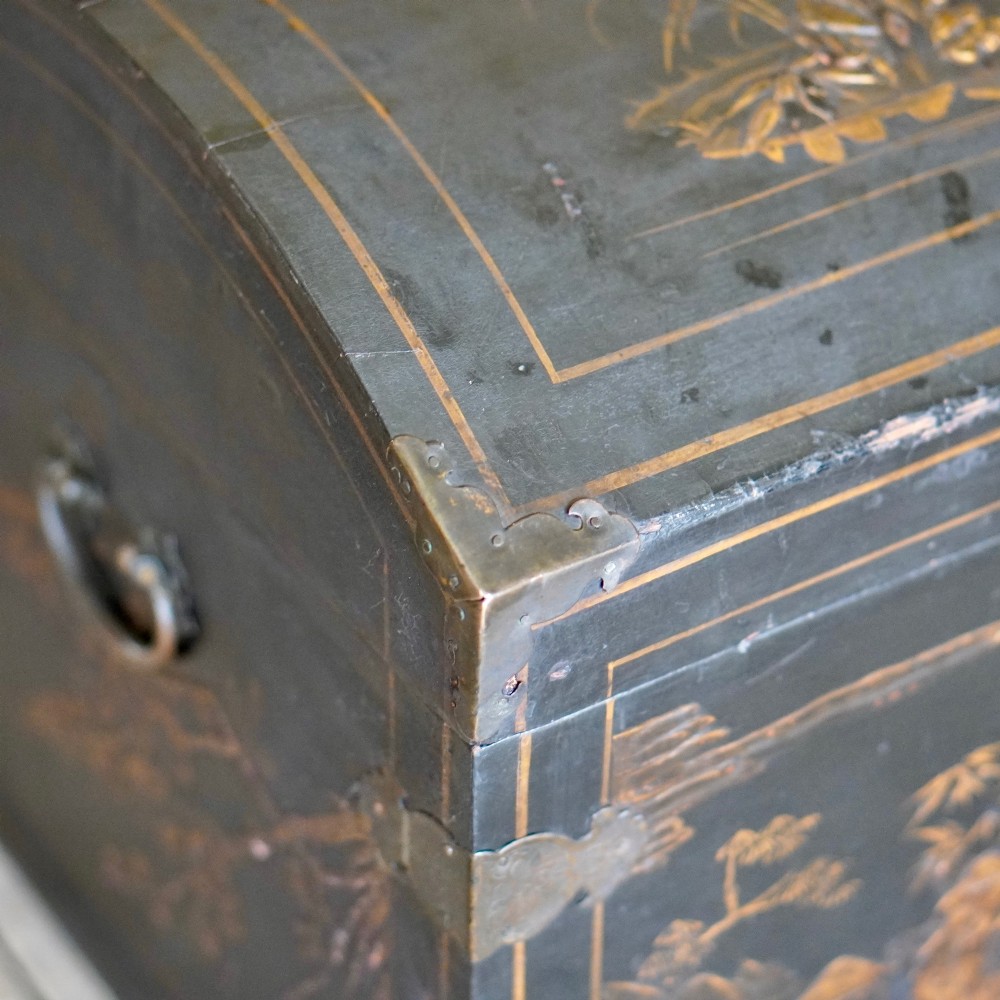 A 19th-century black lacquered domed storage trunk decorated with gilded chinoiserie landscape scenes and metal corner hardware. View IV