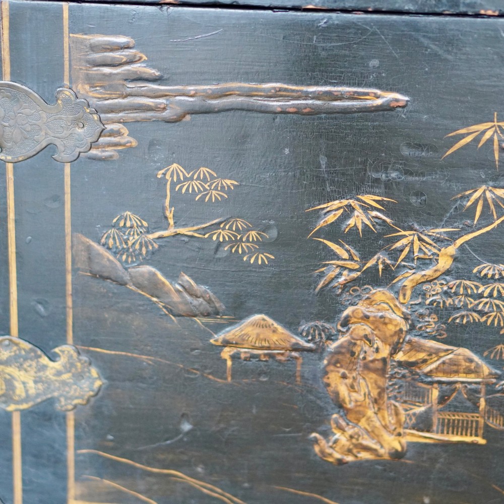 A 19th-century black lacquered domed storage trunk decorated with gilded chinoiserie landscape scenes and metal corner hardware. View V