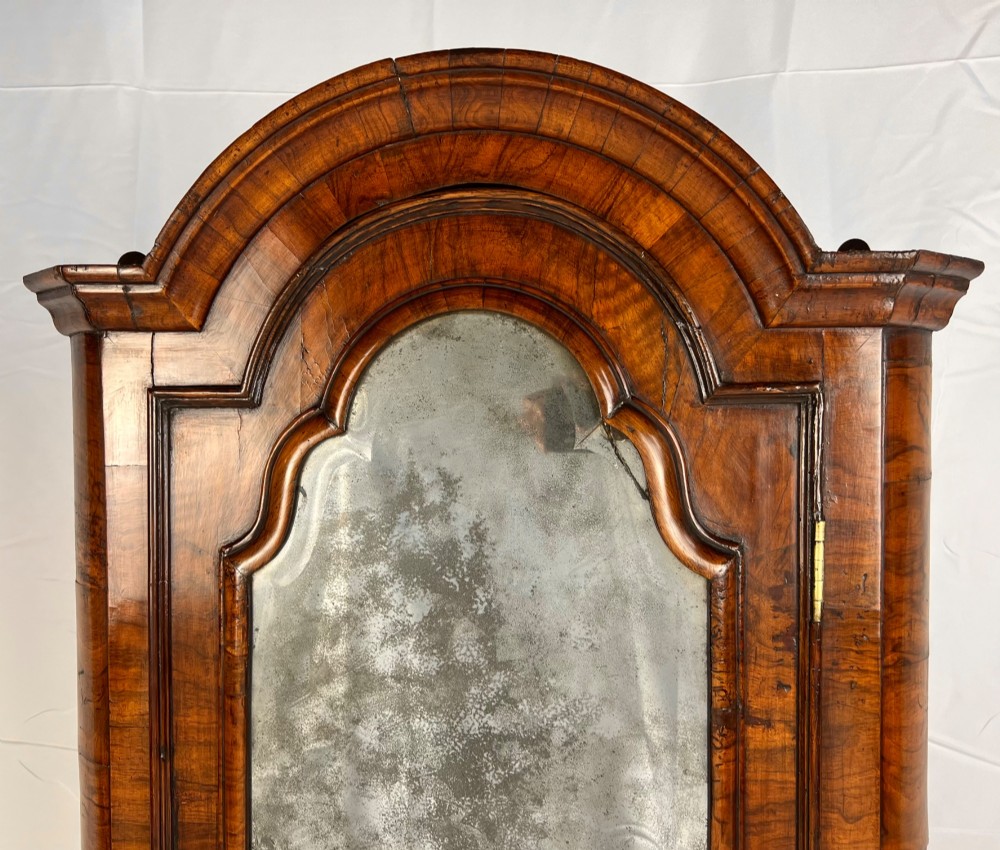 A Queen Anne walnut hanging corner cupboard featuring a double-moulded arched cornice, a mirrored door panel, and an integrated candle slide. View III
