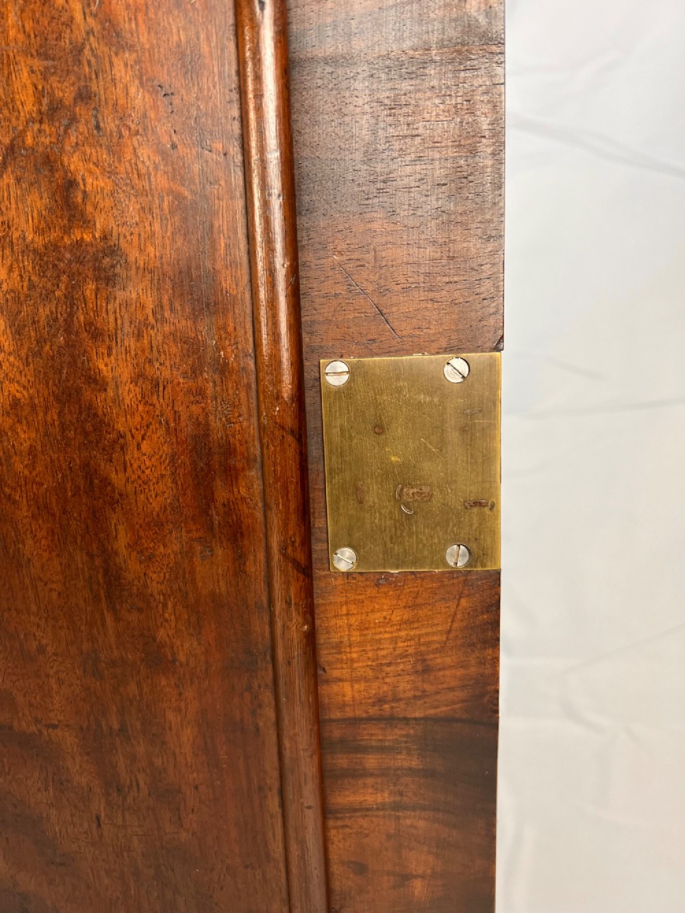 A Queen Anne walnut hanging corner cupboard featuring a double-moulded arched cornice, a mirrored door panel, and an integrated candle slide. View VII