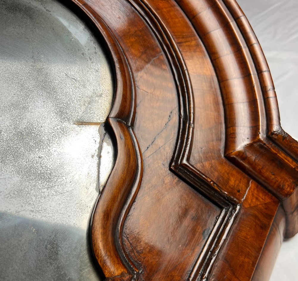A Queen Anne walnut hanging corner cupboard featuring a double-moulded arched cornice, a mirrored door panel, and an integrated candle slide. View X