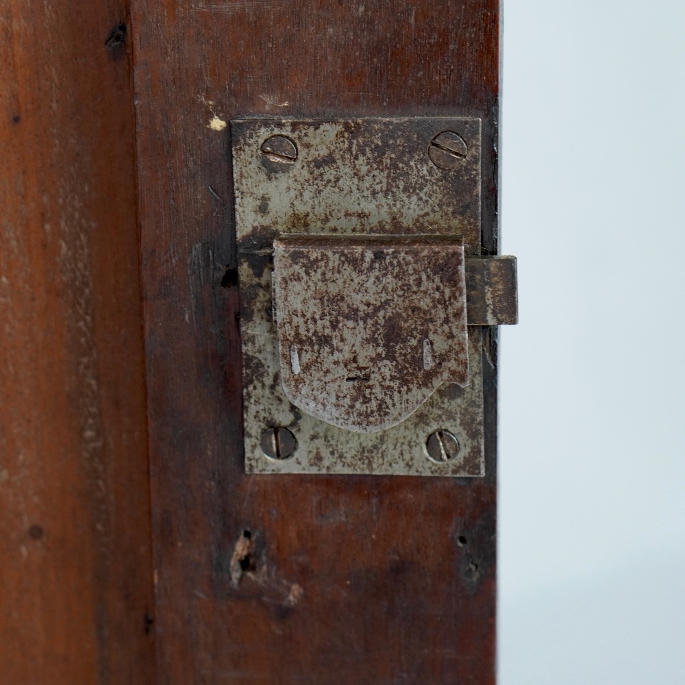 A Georgian mahogany hanging corner cupboard featuring an arched fielded panel door, brass H-hinges, key escutcheon, and a lower drawer. View IX