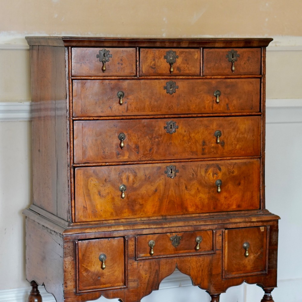 An early eighteenth-century Queen Anne walnut chest on stand featuring multiple drawers, brass teardrop handles, a shaped apron, and turned legs connected by stretchers. View II