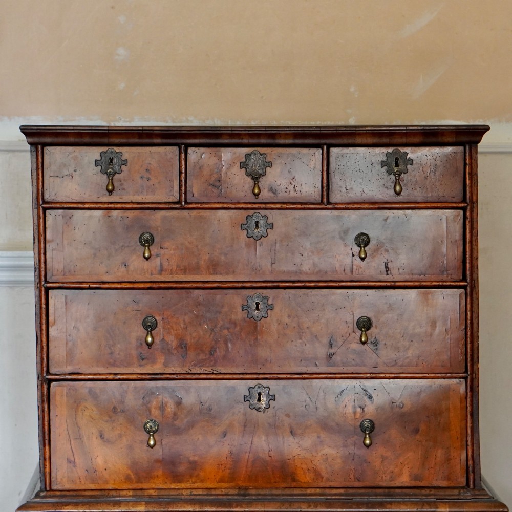 An early eighteenth-century Queen Anne walnut chest on stand featuring multiple drawers, brass teardrop handles, a shaped apron, and turned legs connected by stretchers. View III