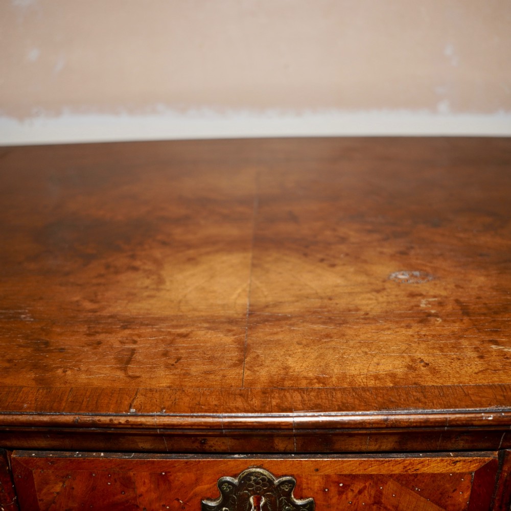 An early eighteenth-century Queen Anne walnut chest on stand featuring multiple drawers, brass teardrop handles, a shaped apron, and turned legs connected by stretchers. View XII