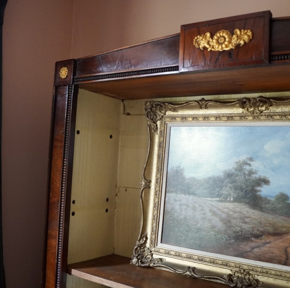 A nineteenth-century French Empire style rosewood open bookcase featuring brass mounts and adjustable shelves above vertical dividers. View III