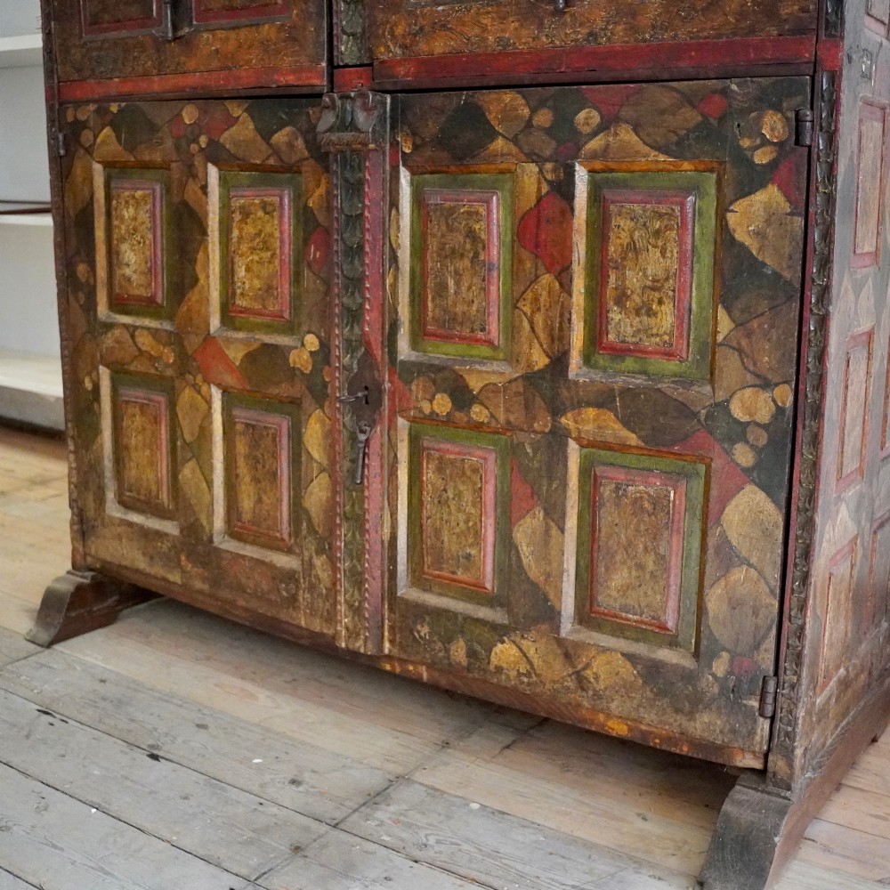 A tall seventeenth-century Spanish oak press cupboard featuring double upper and lower doors decorated with geometric raised panels and painted polychrome geometric patterns. View III