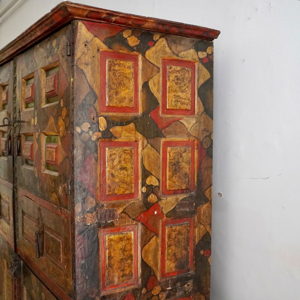 A tall seventeenth-century Spanish oak press cupboard featuring double upper and lower doors decorated with geometric raised panels and painted polychrome geometric patterns. View IV