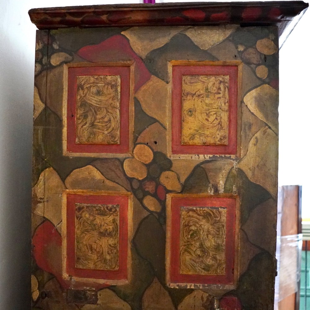 A tall seventeenth-century Spanish oak press cupboard featuring double upper and lower doors decorated with geometric raised panels and painted polychrome geometric patterns. View V
