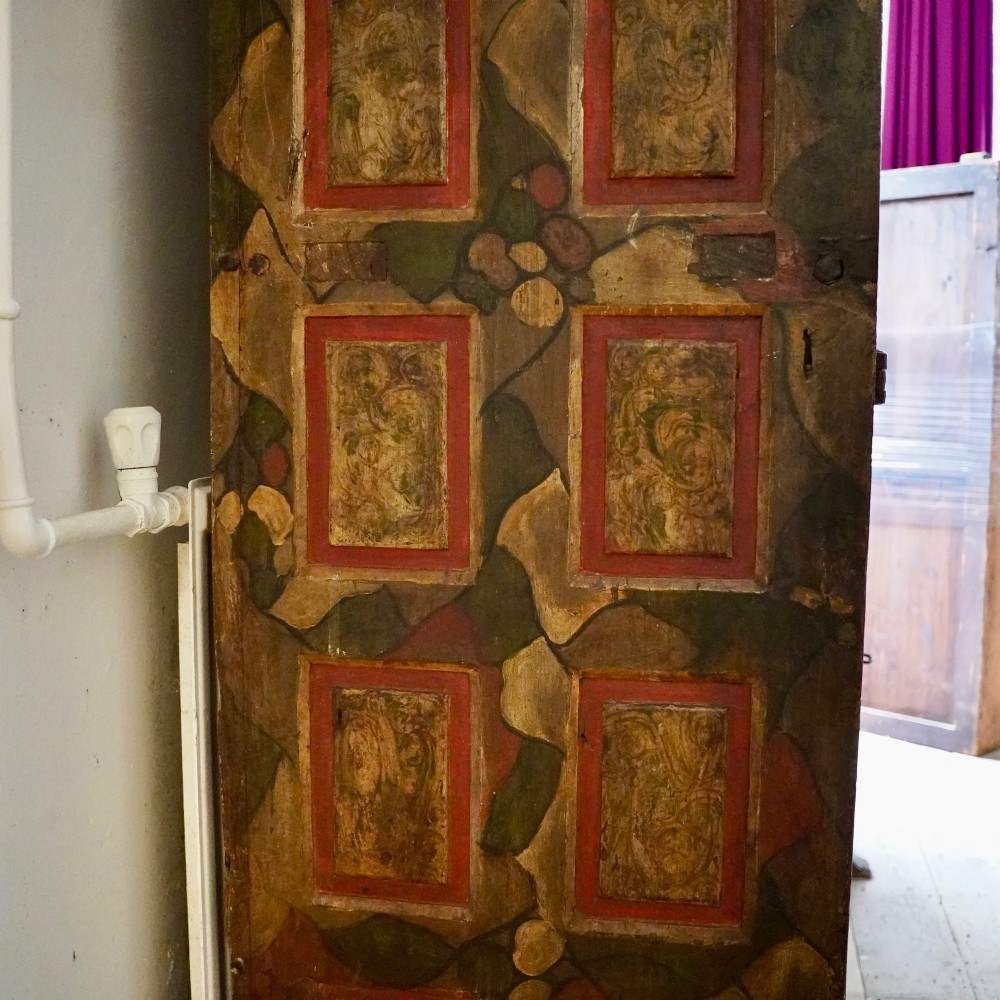 A tall seventeenth-century Spanish oak press cupboard featuring double upper and lower doors decorated with geometric raised panels and painted polychrome geometric patterns. View VI