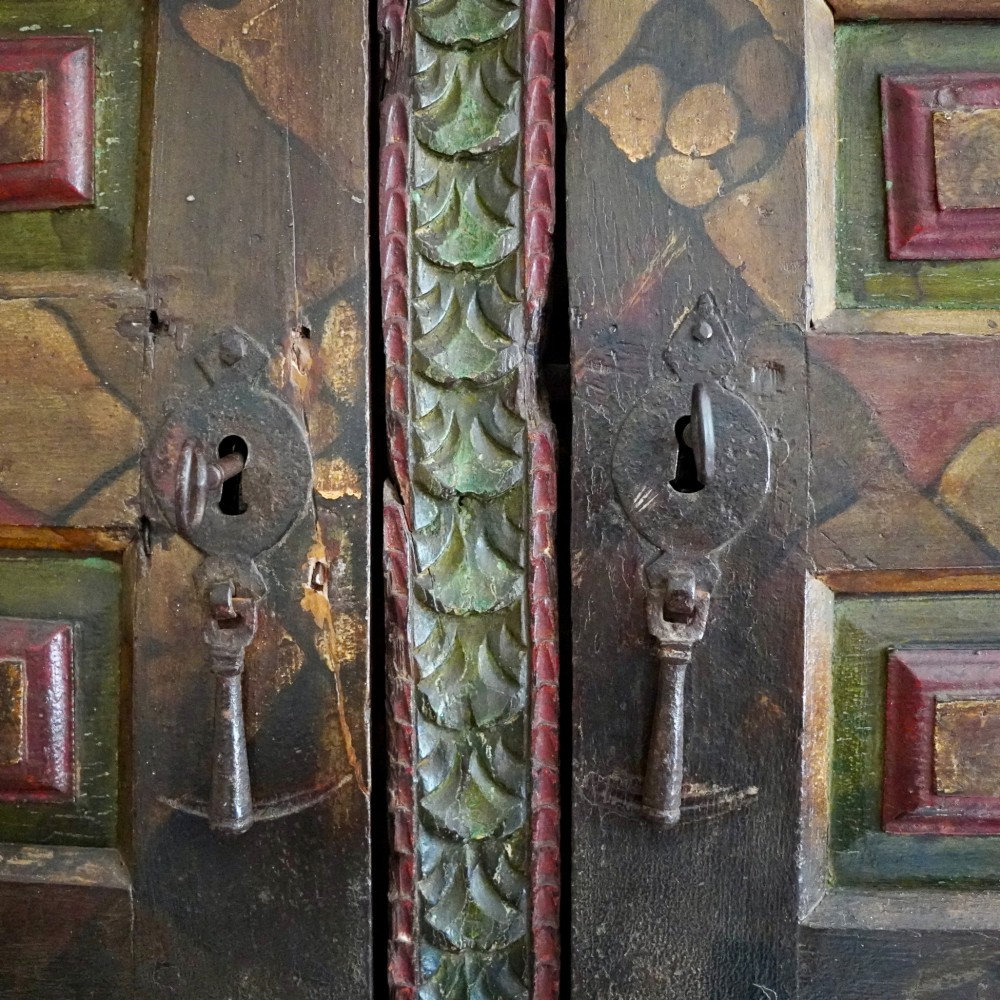 A tall seventeenth-century Spanish oak press cupboard featuring double upper and lower doors decorated with geometric raised panels and painted polychrome geometric patterns. View VIII