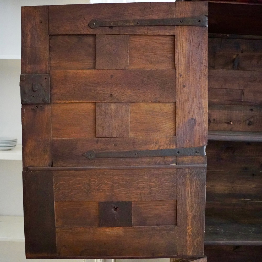 A tall seventeenth-century Spanish oak press cupboard featuring double upper and lower doors decorated with geometric raised panels and painted polychrome geometric patterns. View X