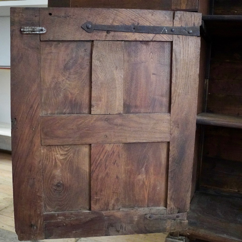 A tall seventeenth-century Spanish oak press cupboard featuring double upper and lower doors decorated with geometric raised panels and painted polychrome geometric patterns. View XI