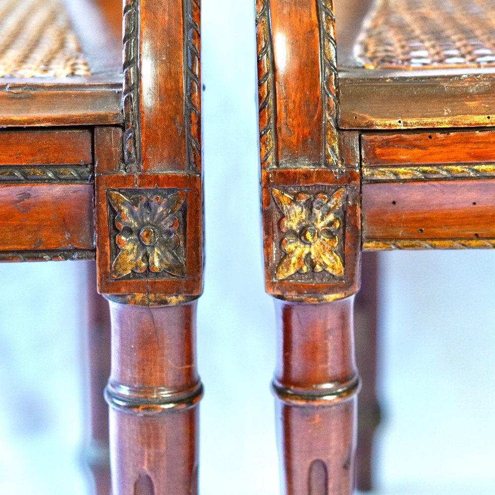 A matching pair of 19th-century Regency style mahogany armchairs featuring carved lyre back splats and woven cane seats. View XII