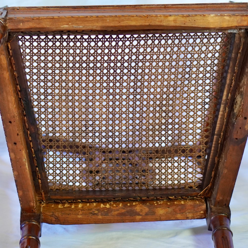 A matching pair of 19th-century Regency style mahogany armchairs featuring carved lyre back splats and woven cane seats. View XIII