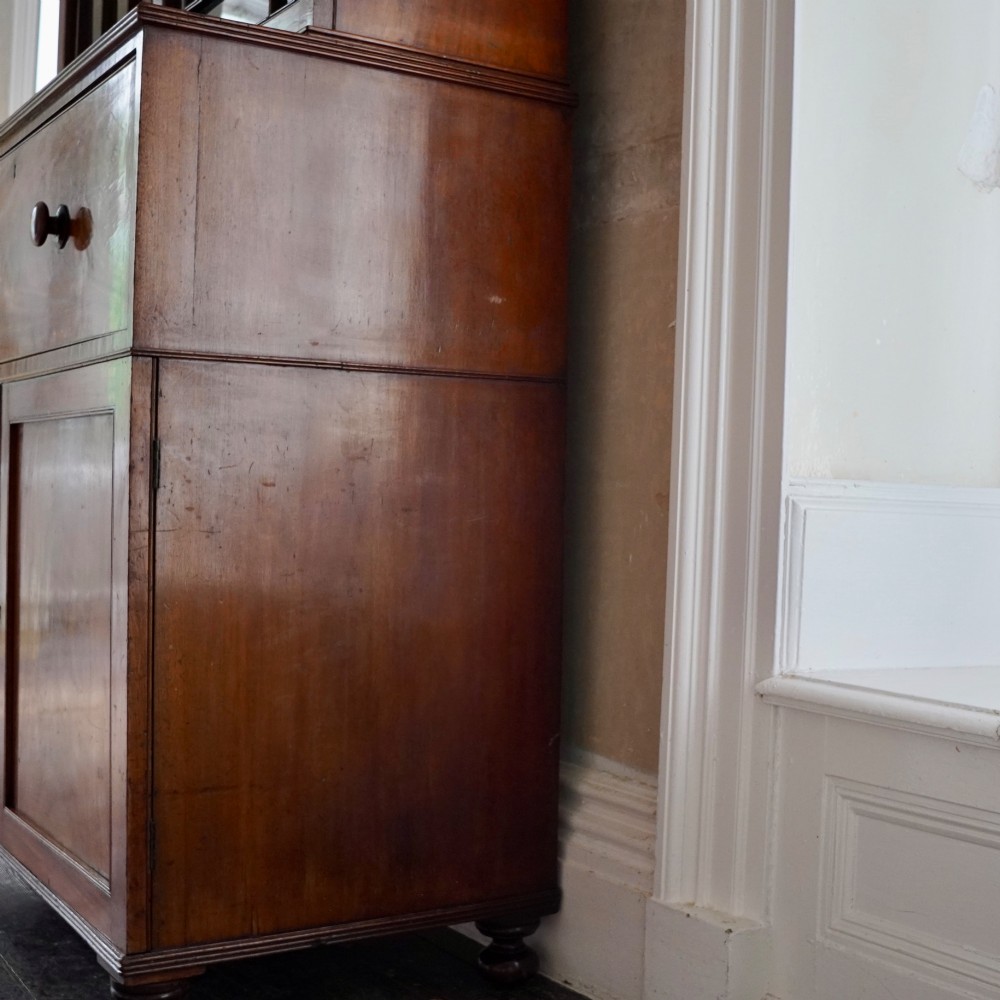 A nineteenth-century George IV mahogany secretaire bookcase with glazed upper doors featuring gothic tracery and a drop-down desk drawer revealing a fitted interior. View V
