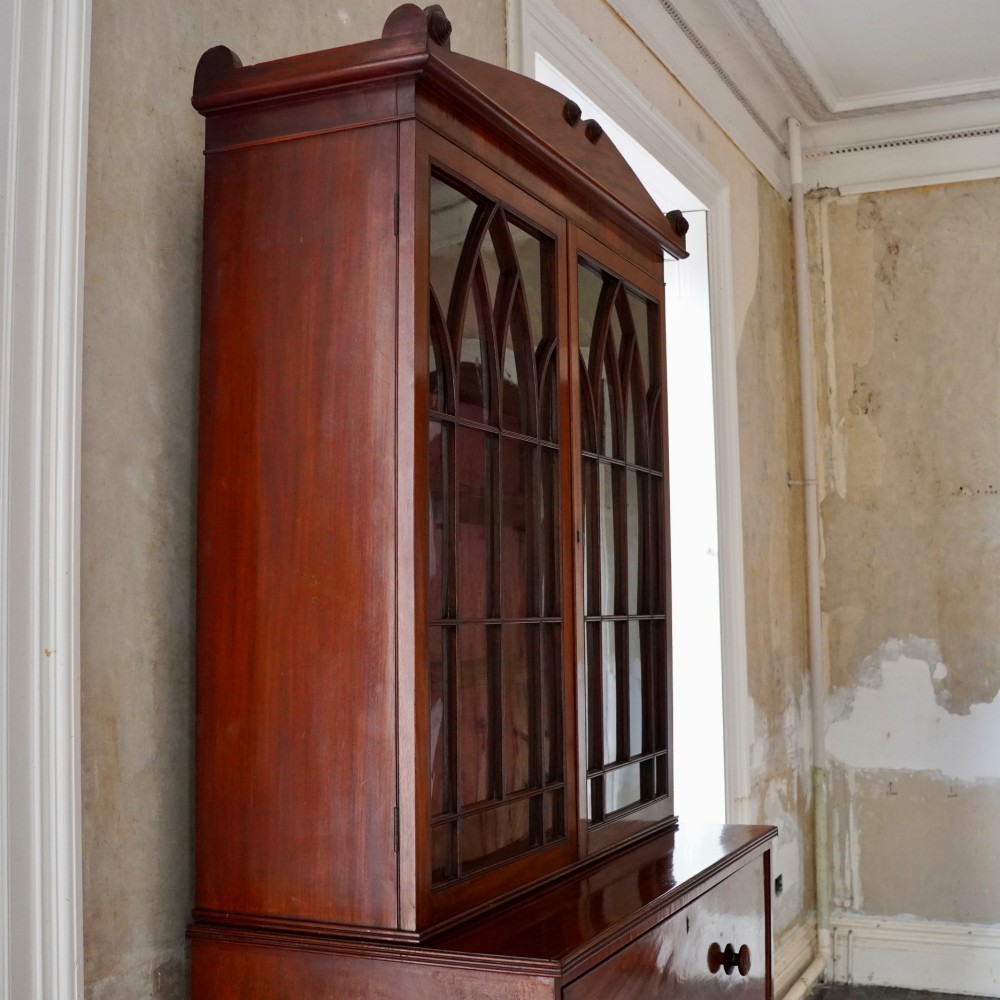 A nineteenth-century George IV mahogany secretaire bookcase with glazed upper doors featuring gothic tracery and a drop-down desk drawer revealing a fitted interior. View VI