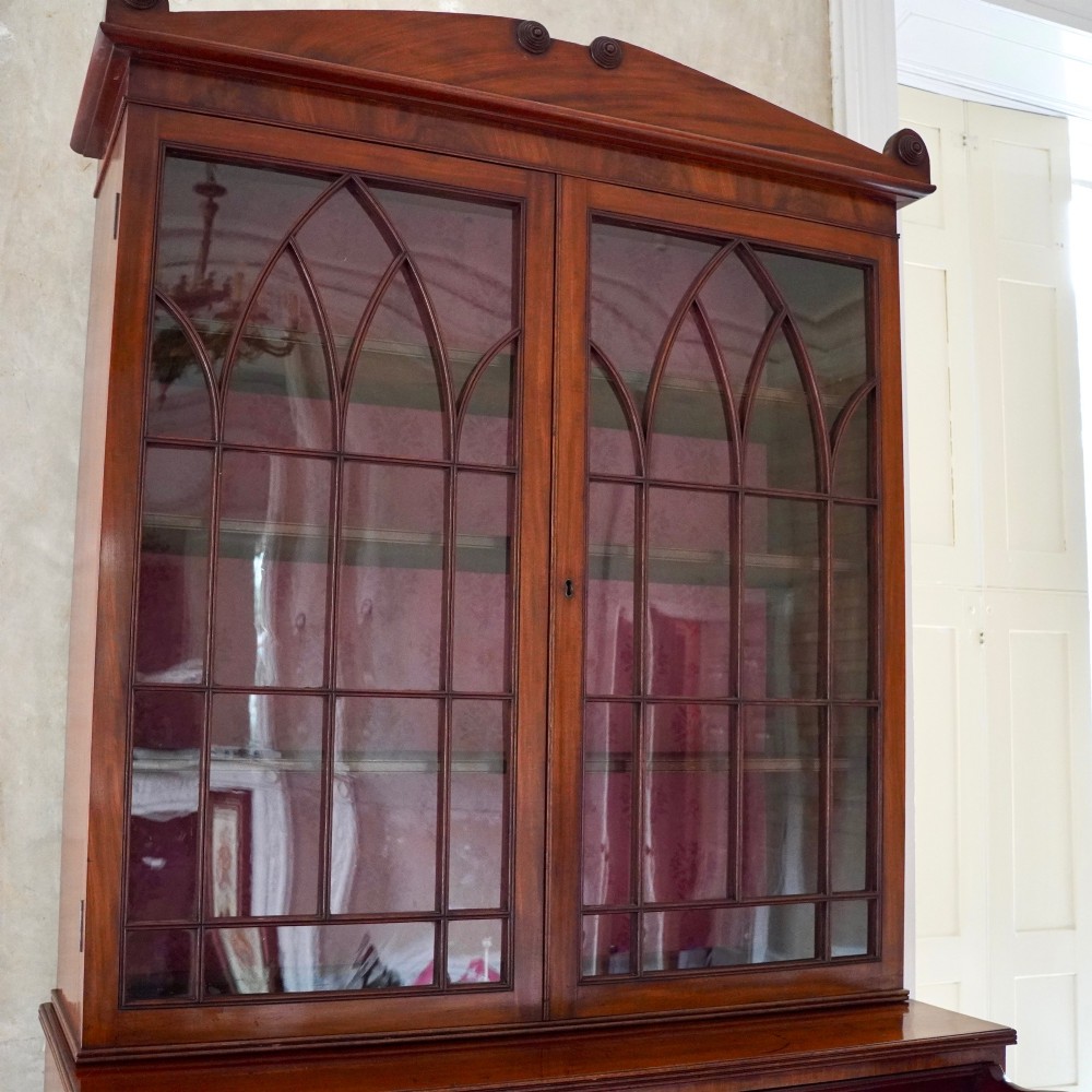 A nineteenth-century George IV mahogany secretaire bookcase with glazed upper doors featuring gothic tracery and a drop-down desk drawer revealing a fitted interior. View IX