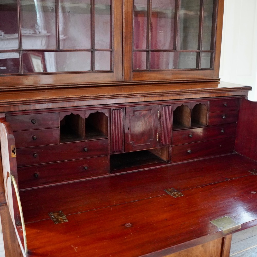 A nineteenth-century George IV mahogany secretaire bookcase with glazed upper doors featuring gothic tracery and a drop-down desk drawer revealing a fitted interior. View XI