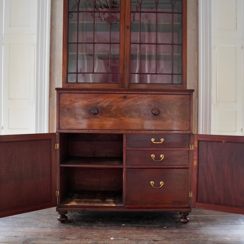 A nineteenth-century George IV mahogany secretaire bookcase with glazed upper doors featuring gothic tracery and a drop-down desk drawer revealing a fitted interior. View XII