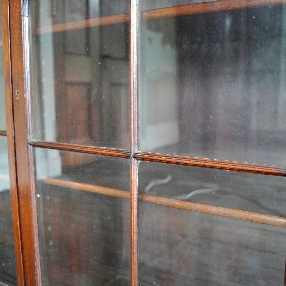 A large Victorian dark mahogany breakfront glazed bookcase featuring three doors with Gothic arch astragal glazing bars and a fluted cornice. View VII