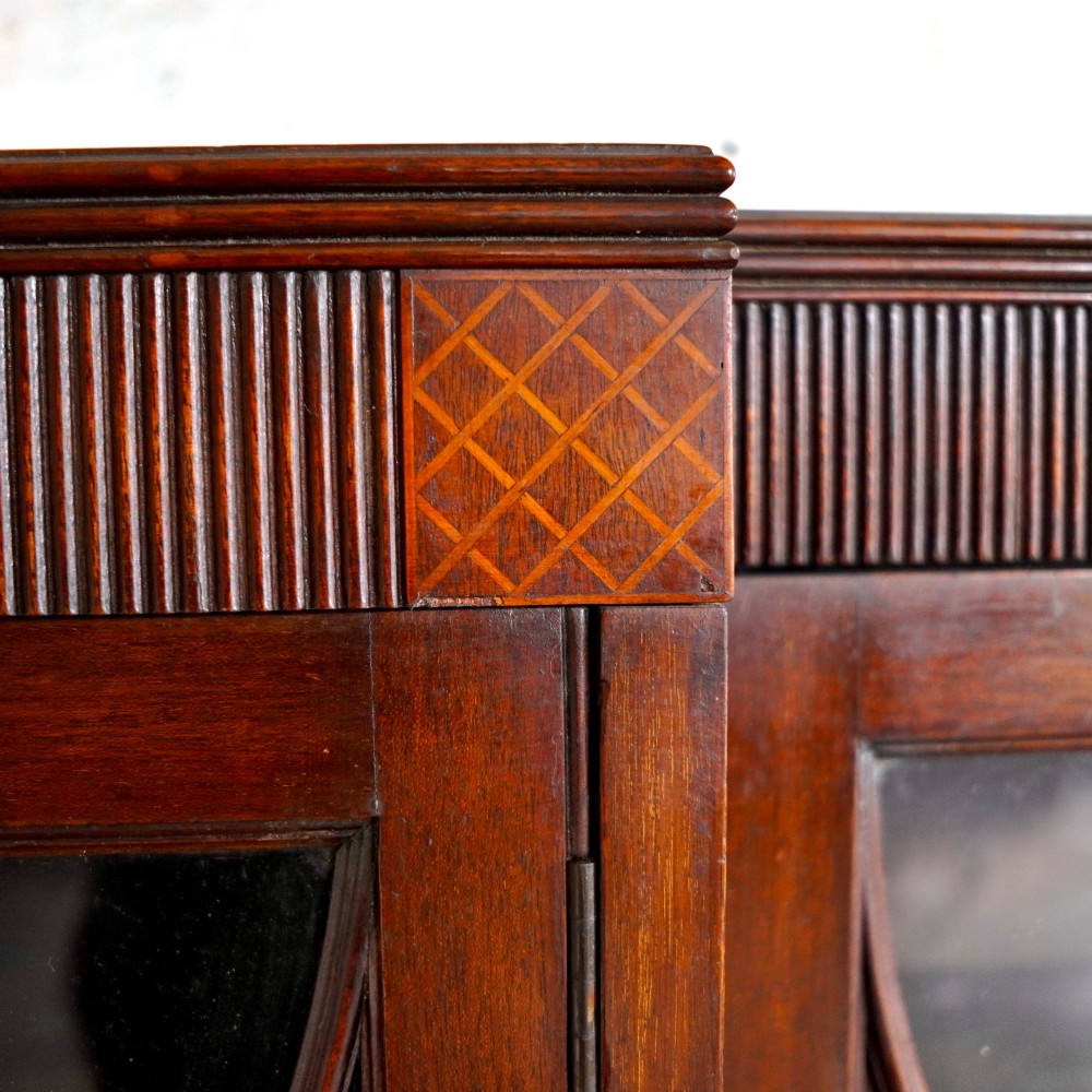 A large Victorian dark mahogany breakfront glazed bookcase featuring three doors with Gothic arch astragal glazing bars and a fluted cornice. View X