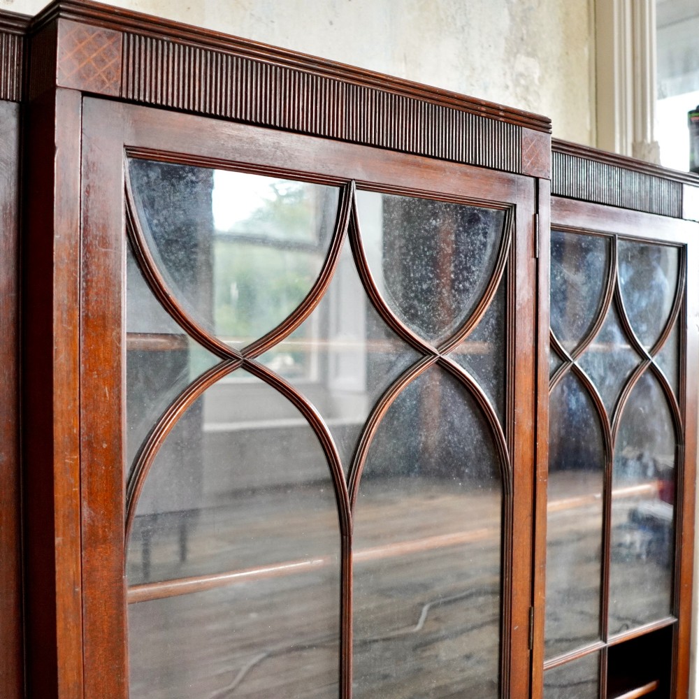 A large Victorian dark mahogany breakfront glazed bookcase featuring three doors with Gothic arch astragal glazing bars and a fluted cornice. View XII
