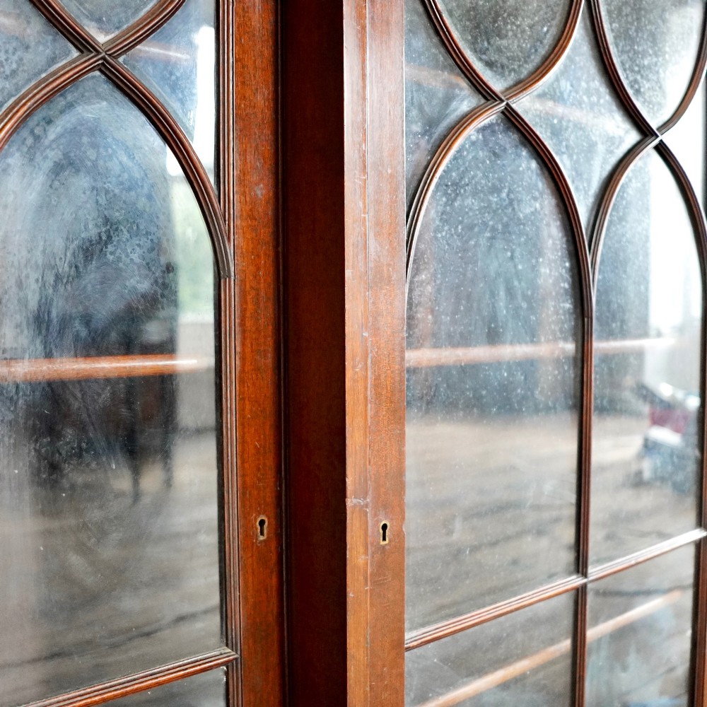 A large Victorian dark mahogany breakfront glazed bookcase featuring three doors with Gothic arch astragal glazing bars and a fluted cornice. View XIII