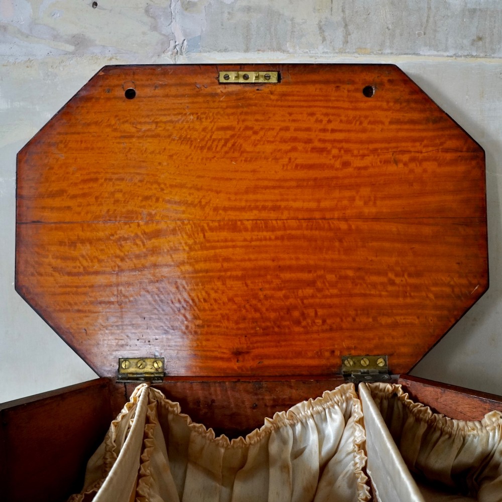 An octagonal George III satinwood work table with two drawers, lion mask ring handles, and tapered legs ending in brass castors. View VII