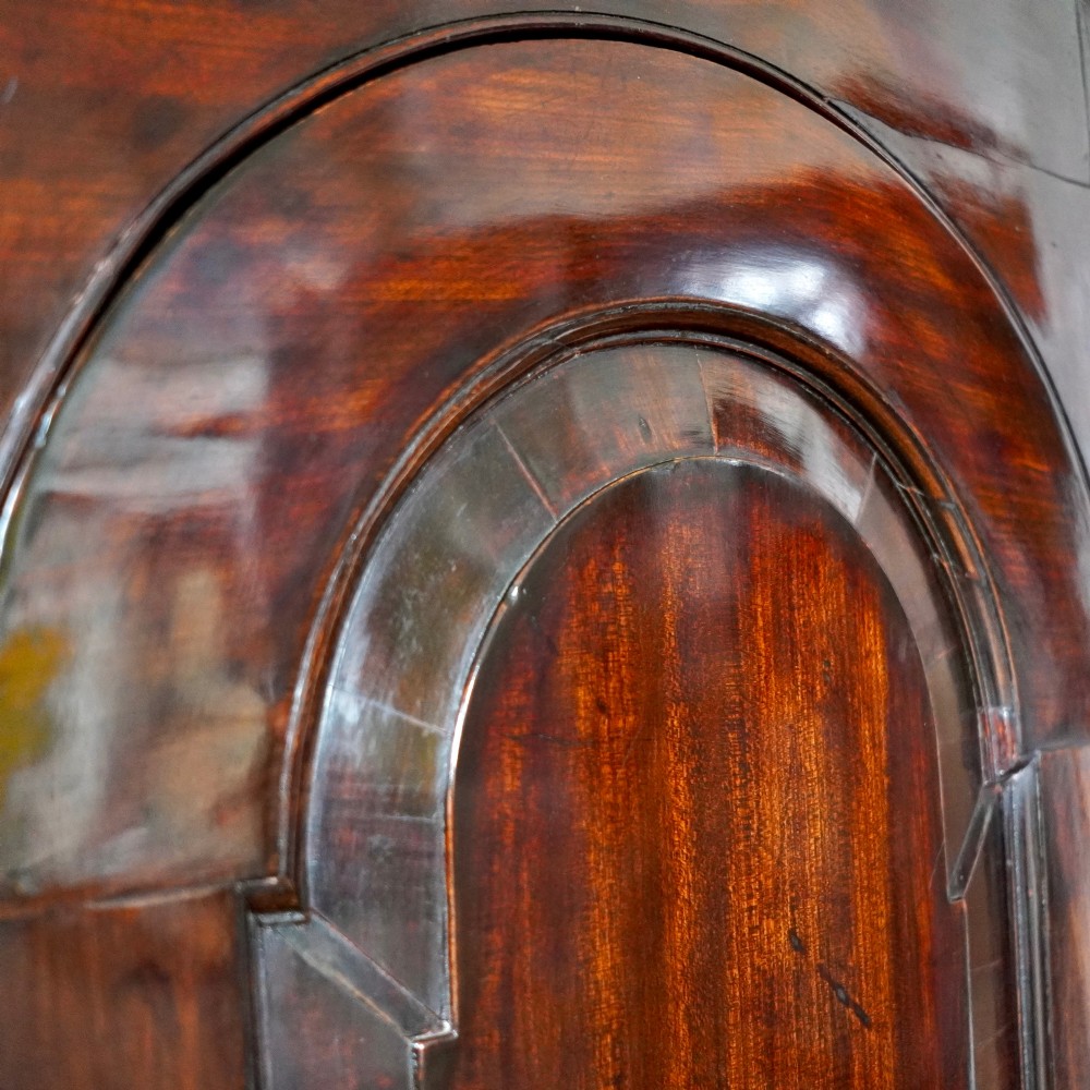 Mid-18th century Georgian mahogany hanging corner cupboard featuring an arched panelled door, brass hardware, and fluted pilasters. View X