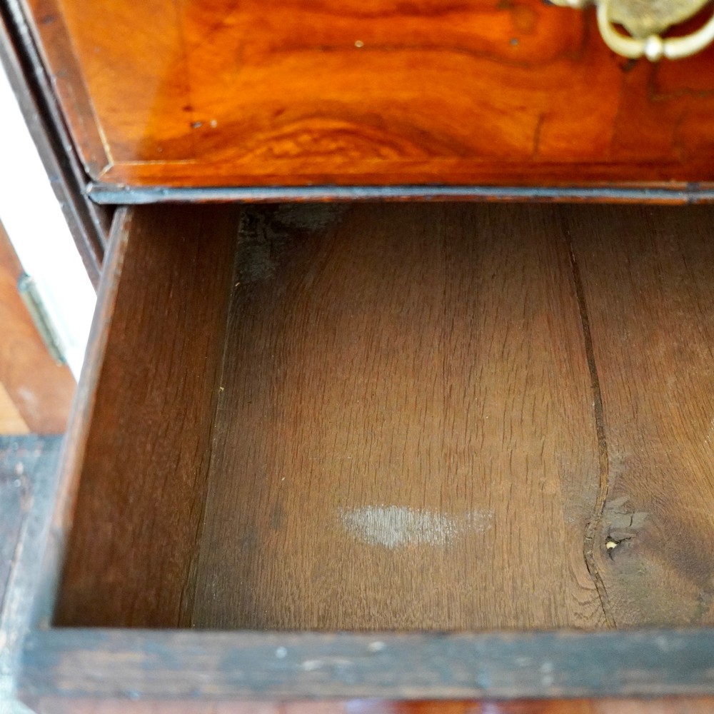 A George I period figured walnut chest on stand featuring engraved brass escutcheons and six barley-twist legs. View VI