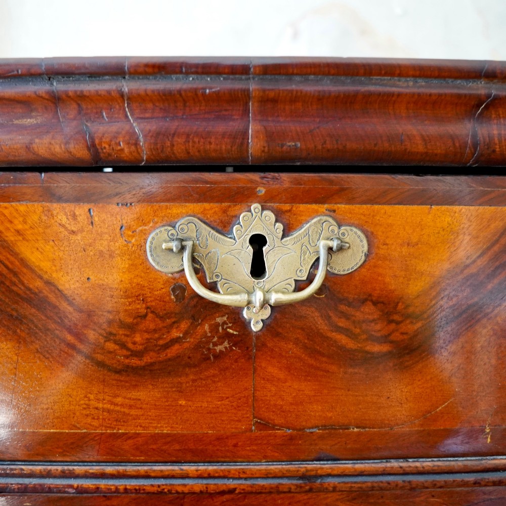 A George I period figured walnut chest on stand featuring engraved brass escutcheons and six barley-twist legs. View VIII