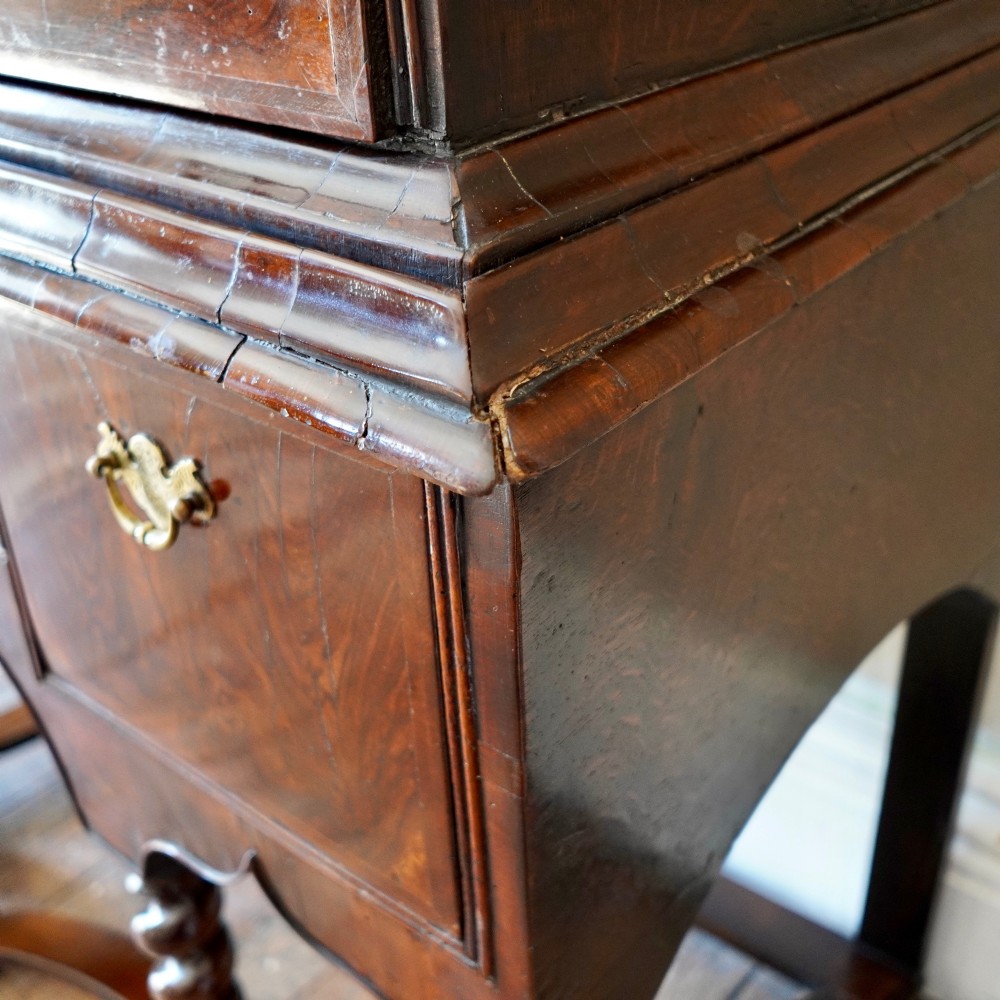 A George I period figured walnut chest on stand featuring engraved brass escutcheons and six barley-twist legs. View IX