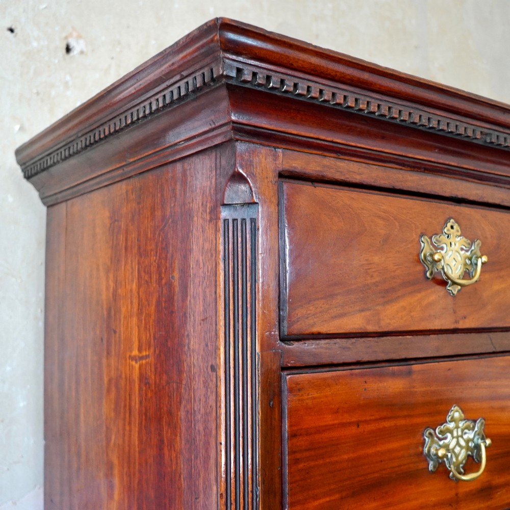 A late 18th-century George III mahogany chest on chest featuring brass swan-neck handles, keyhole escutcheons, dentil moulding, and bracket feet. View V