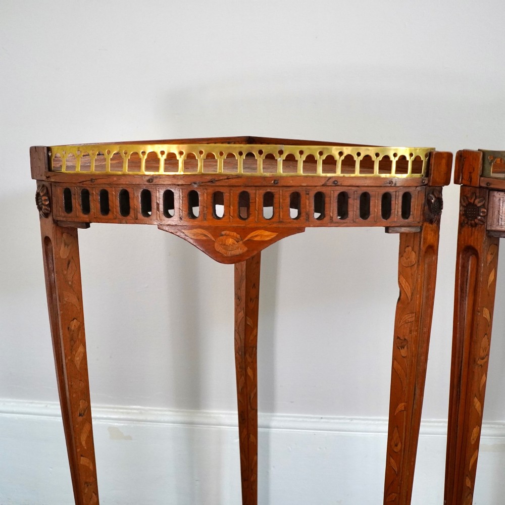 A pair of 18th-century triangular corner tables featuring detailed floral marquetry top surfaces, pierced friezes, tapering legs, and brass galleries. View V
