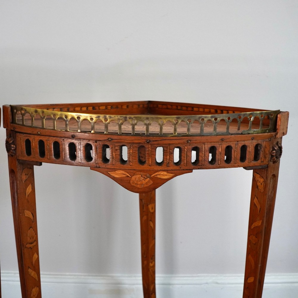 A pair of 18th-century triangular corner tables featuring detailed floral marquetry top surfaces, pierced friezes, tapering legs, and brass galleries. View VI