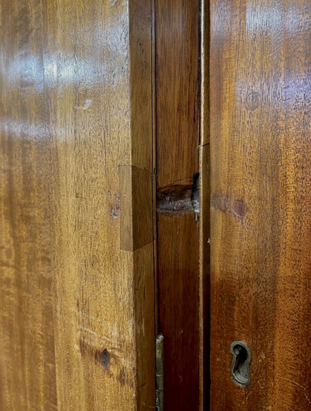 A large George III mahogany breakfront linen press wardrobe featuring central panelled doors above drawers, flanked by side cupboards on bracket feet. View IX